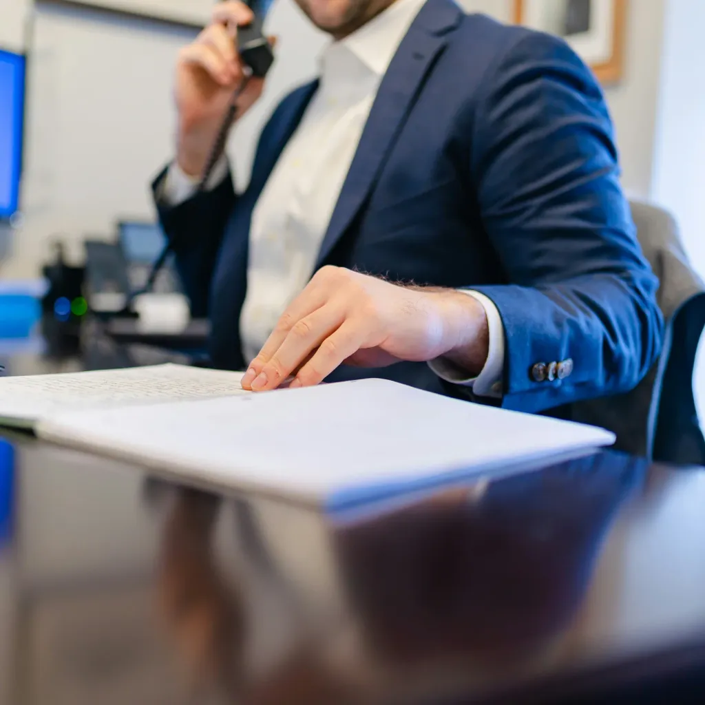 A business owner signing papers at an office desk
