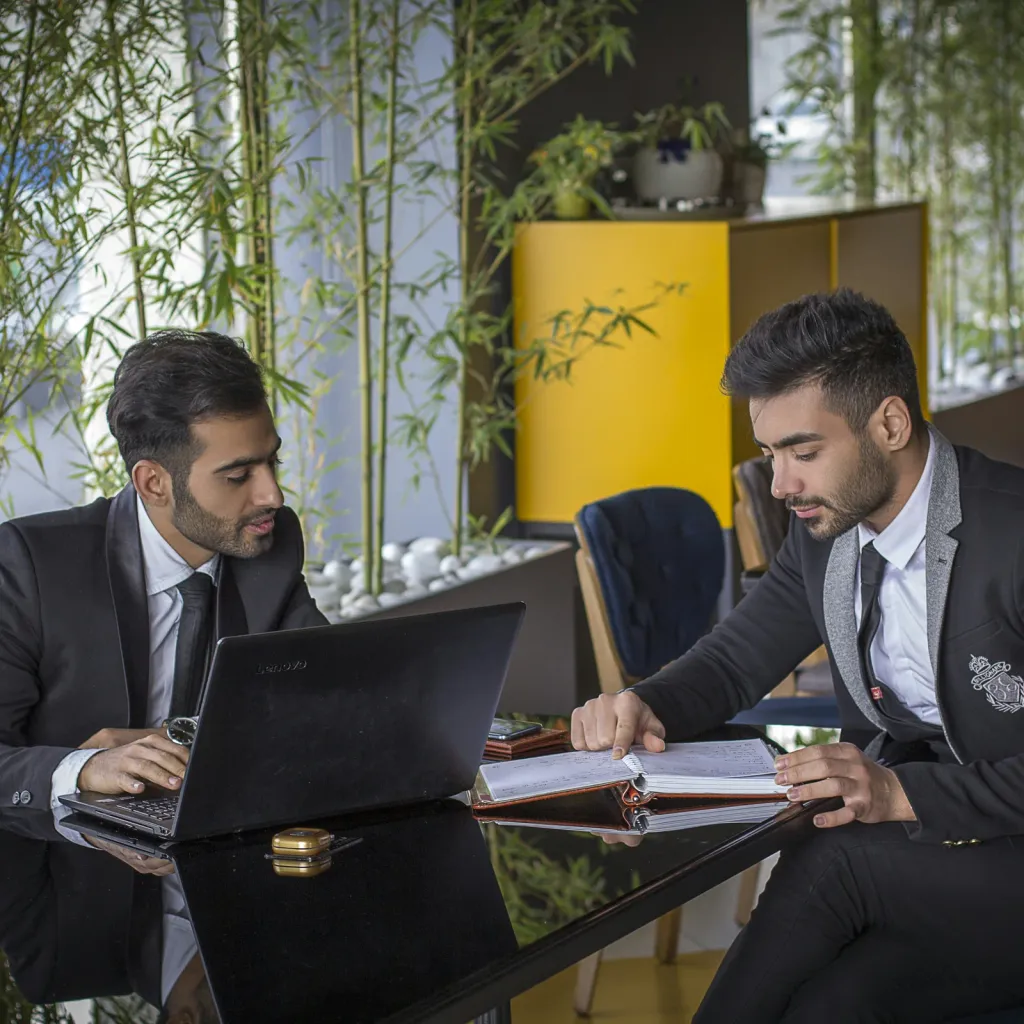 Two business partners reviewing documents together in a modern office