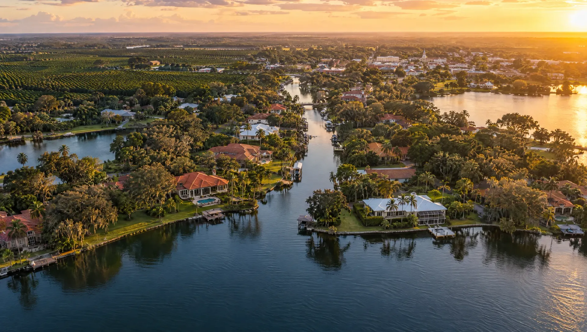 Aerial view of Central Florida lakes, canals, waterfront homes and citrus groves at sunset
