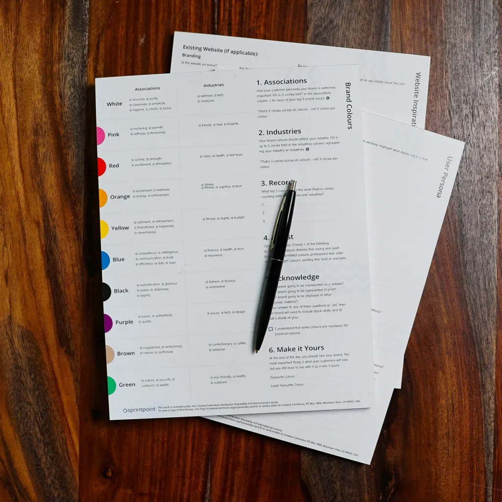 A stack of contract pages and a pen on a wooden desk
